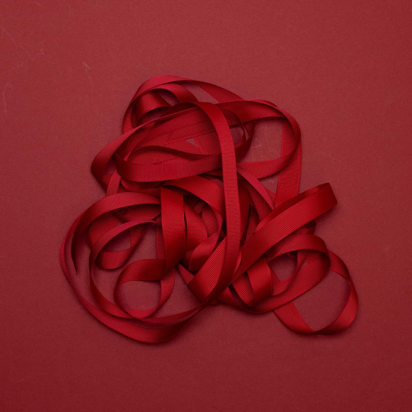 Tamsiai raudonos spalvos dovanų rišimo kaspinas–juostelė